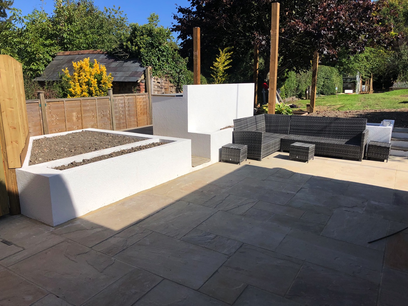 White K-Rend planters with sandstone paving installed in Hampshire.