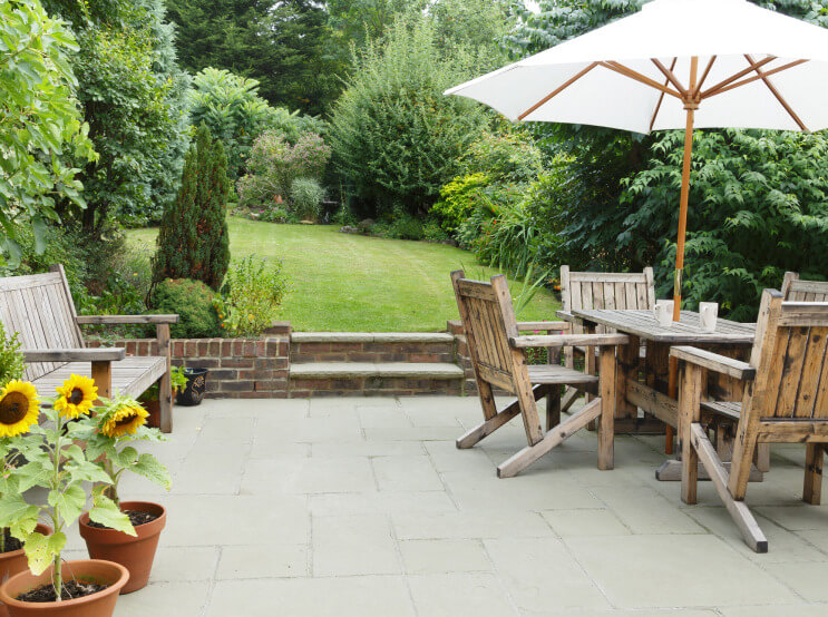 Grey sandstone paving that's been repaired in a garden in Hampshire.